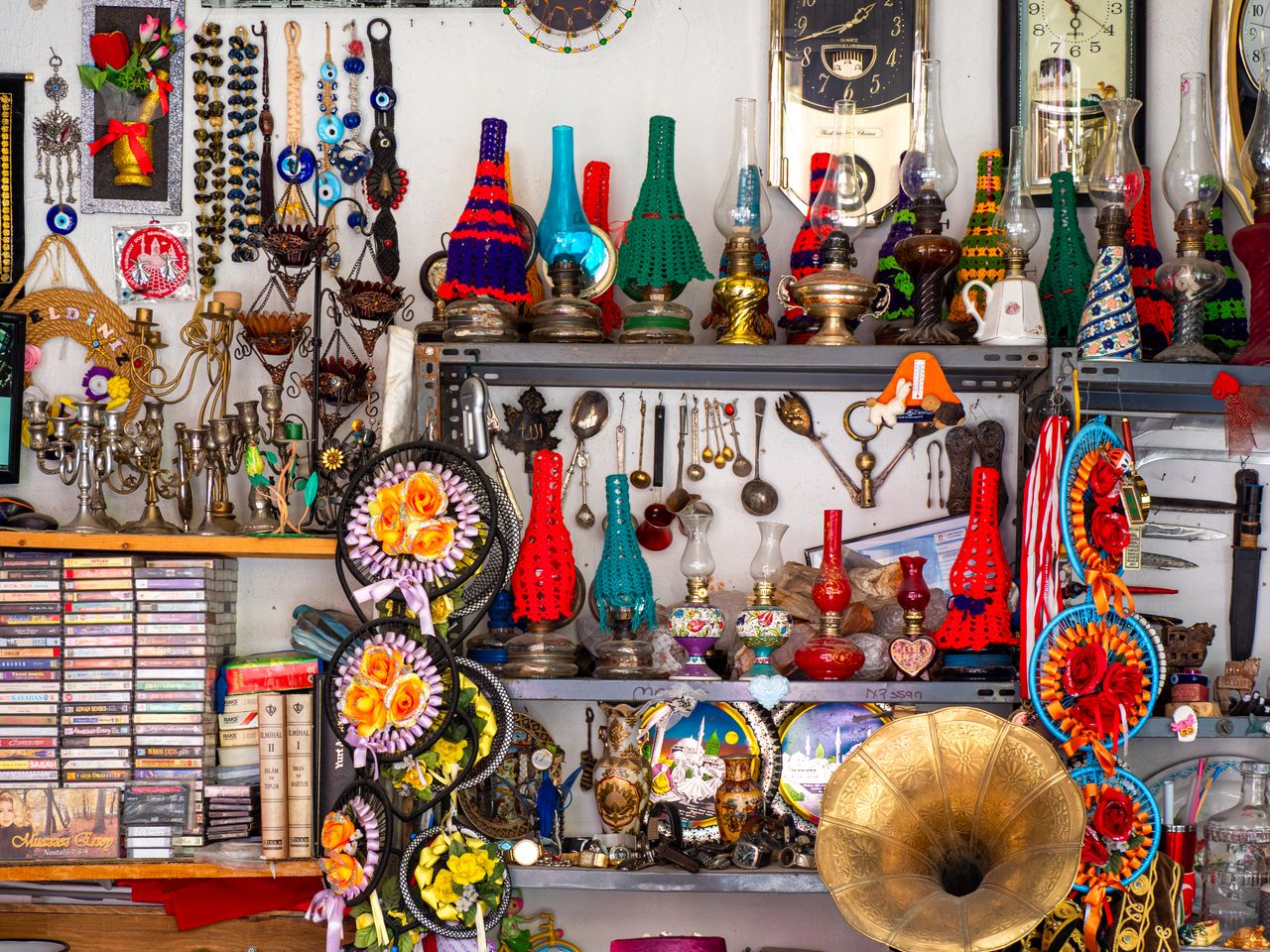 services-01 A vibrant display of vintage collectibles including lanterns, gramophone, and cultural artifacts on a shelf.