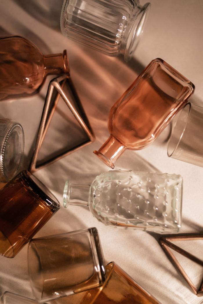 services-01 A creative arrangement of glass bottles and geometric shapes in warm tones.