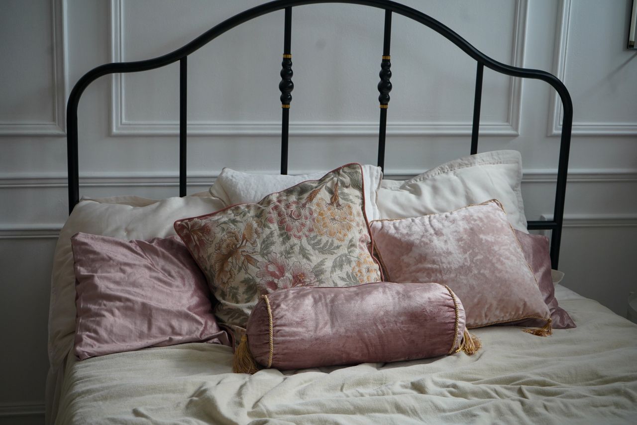 home-img A cozy and elegant bedroom setup featuring decorative cushions and a classic bed.